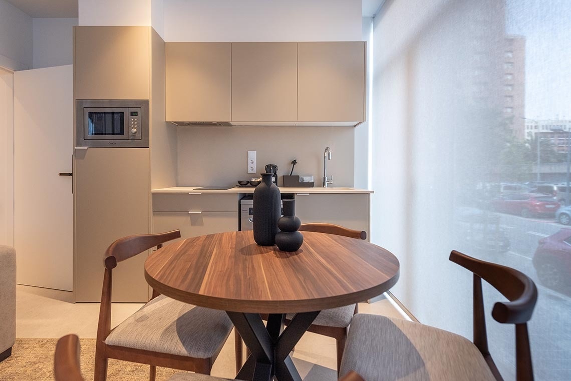 una cocina pequeña con una mesa de madera y sillas