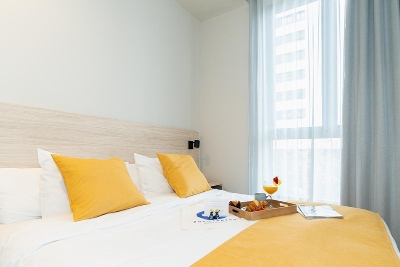 una cama con sábanas blancas y almohadas blancas