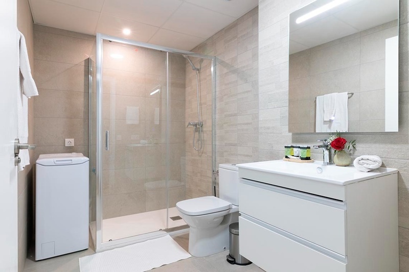 una cama con sábanas blancas y almohadas blancas