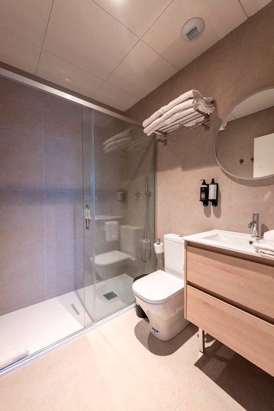 una cama con sábanas blancas y almohadas blancas