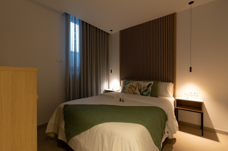 una cama con dos almohadas blancas y una cabecera de madera