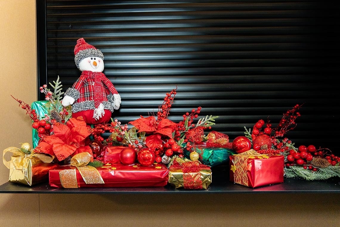 un muñeco de nieve se sienta encima de un montón de regalos de navidad