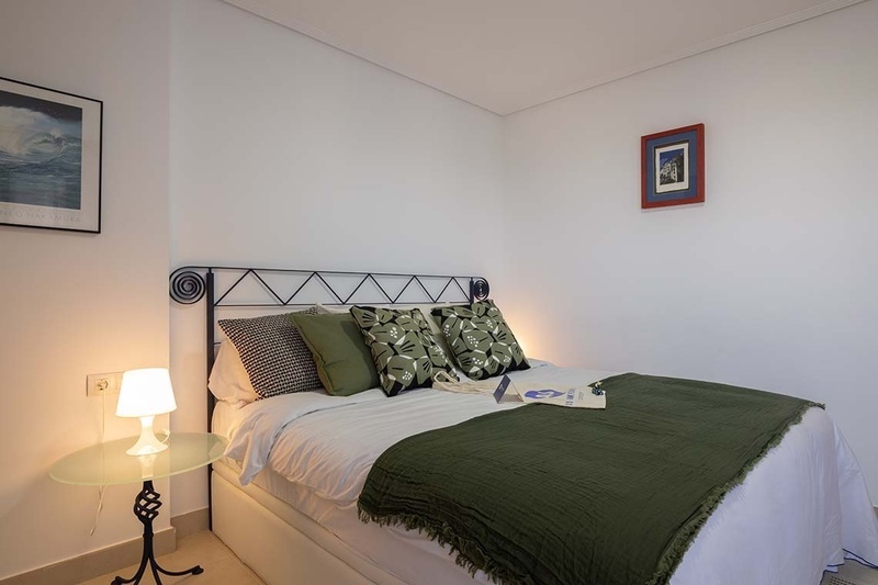 una cama con dos almohadas blancas y una cabecera de madera