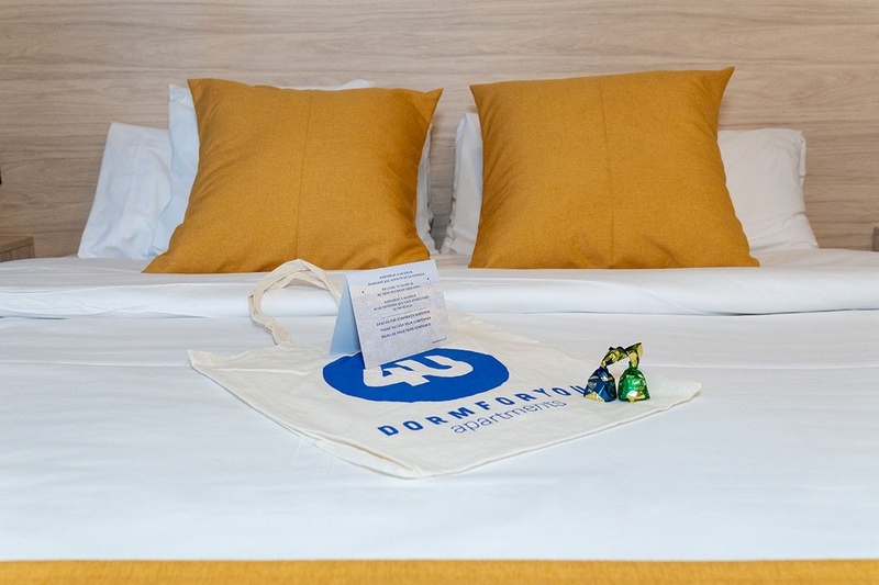 una cama con dos almohadas blancas y una cabecera de madera