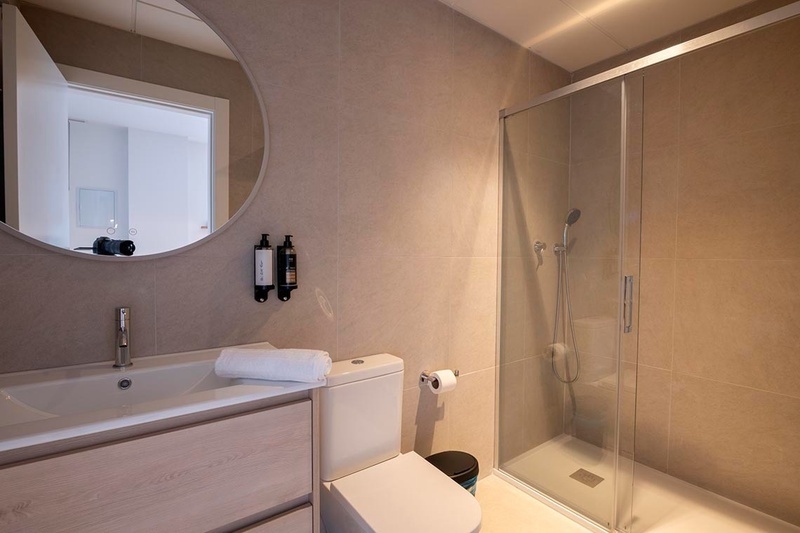 una cama con sábanas blancas y almohadas blancas