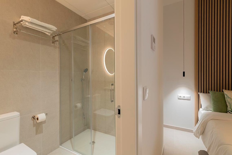 una cama con sábanas blancas y almohadas blancas