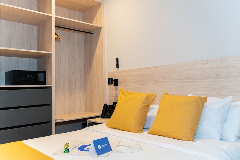 una habitación con una cama y un árbol en la pared