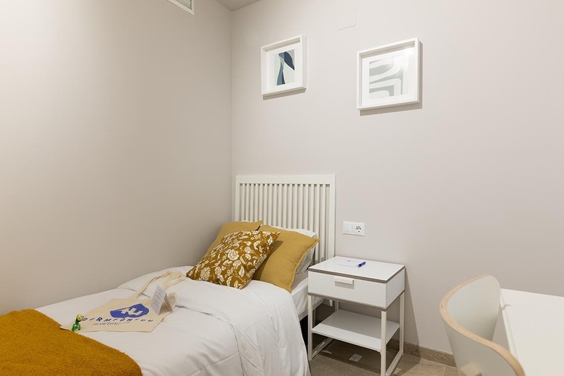 una cama con dos almohadas blancas y una cabecera de madera