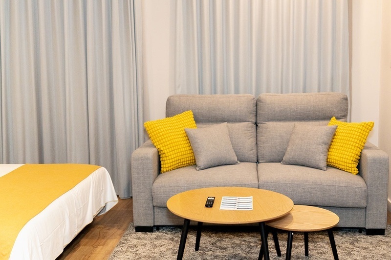 una habitación con una cama y un árbol en la pared