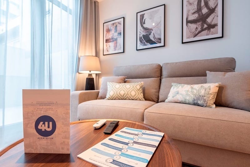 una cama con sábanas blancas y almohadas blancas