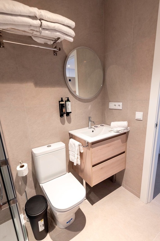 una cama con sábanas blancas y almohadas blancas