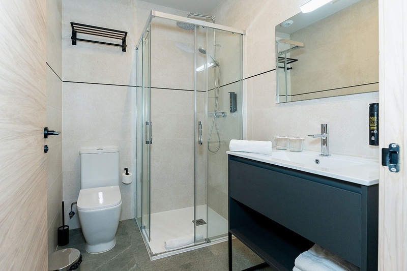 una cama con dos almohadas blancas y una cabecera de madera