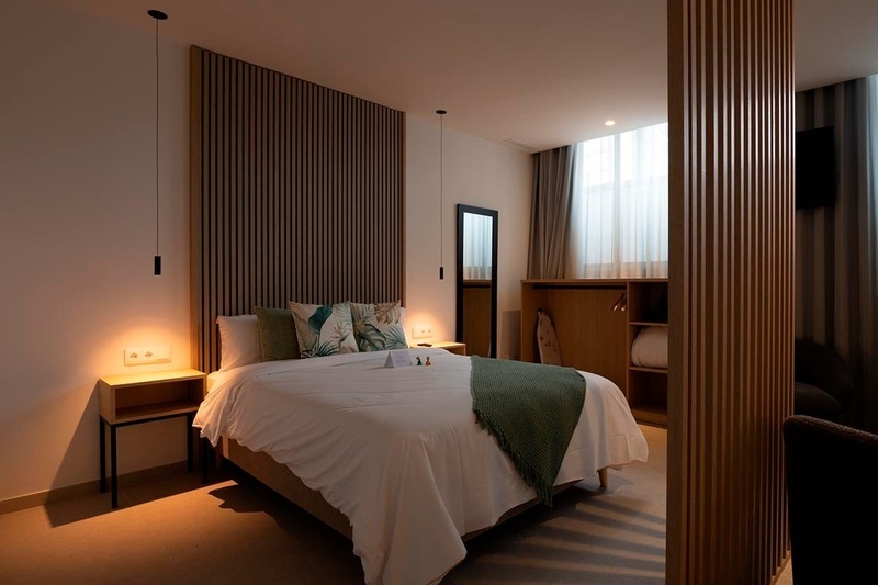 una cama con sábanas blancas y almohadas blancas