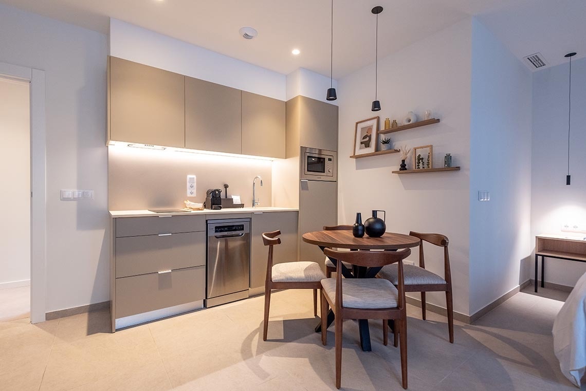 una pequeña cocina con una mesa y sillas