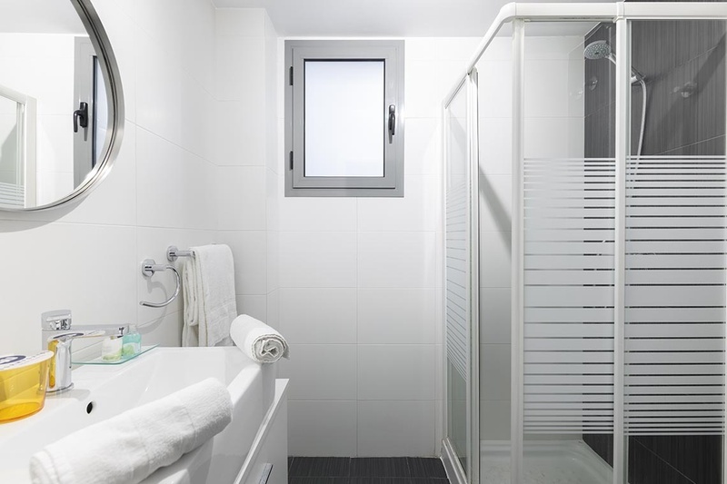 una cama con dos almohadas blancas y una cabecera de madera