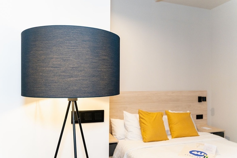 una habitación con una cama y un árbol en la pared