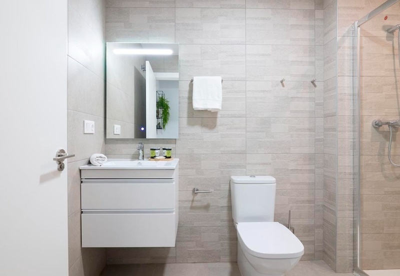 una cama con sábanas blancas y almohadas blancas