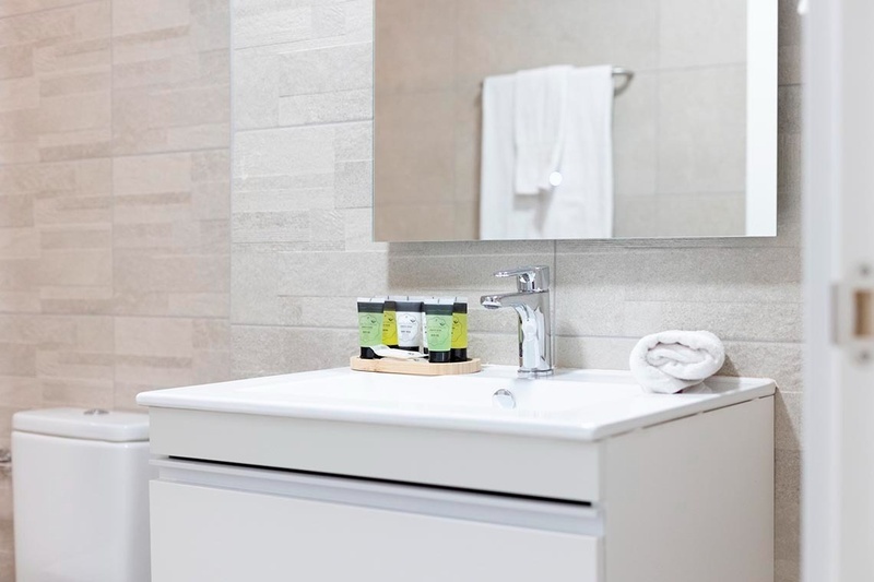 una cama con sábanas blancas y almohadas blancas