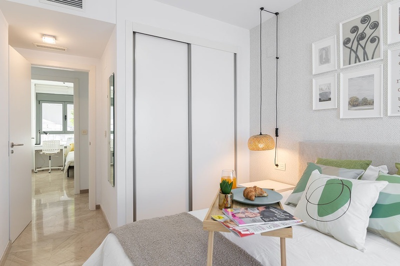 una cama con dos almohadas blancas y una cabecera de madera