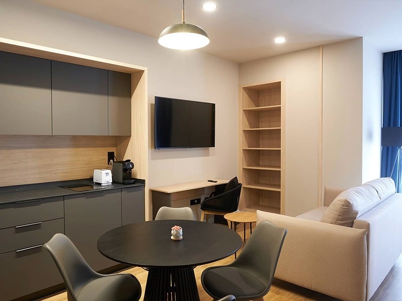 una cocina con una mesa y sillas y un televisor en la pared