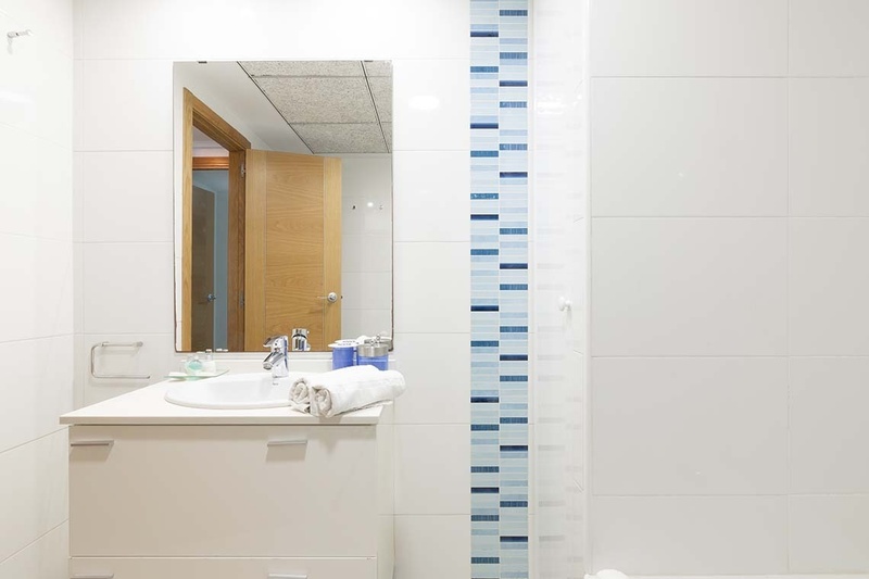 una cama con dos almohadas blancas y una cabecera de madera