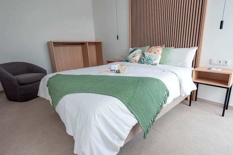 una cama con sábanas blancas y almohadas blancas