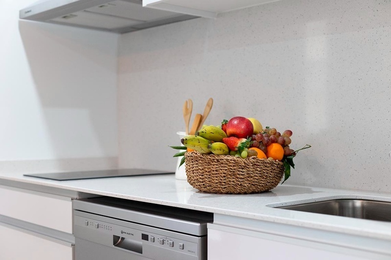 una cama con sábanas blancas y almohadas blancas