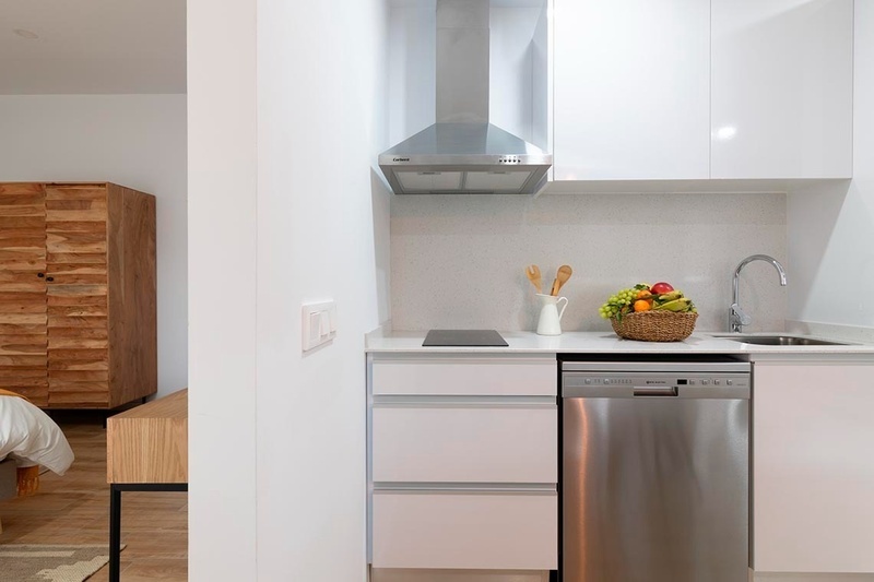 una cama con sábanas blancas y almohadas blancas