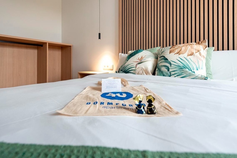 una cama con sábanas blancas y almohadas blancas