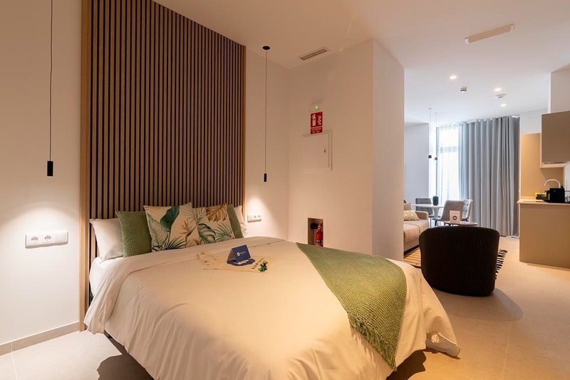 una cama con sábanas blancas y almohadas blancas