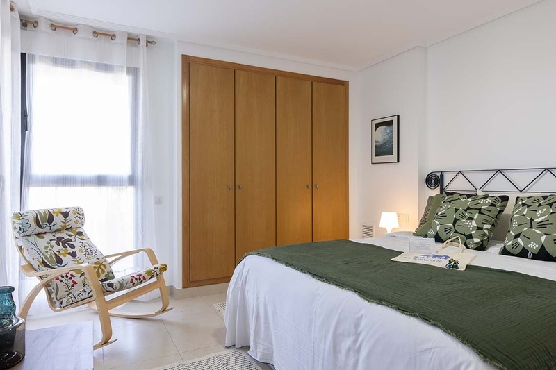 una cama con dos almohadas blancas y una cabecera de madera