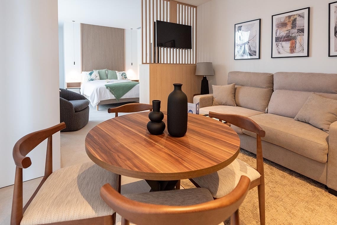 una habitación con una mesa de madera y sillas