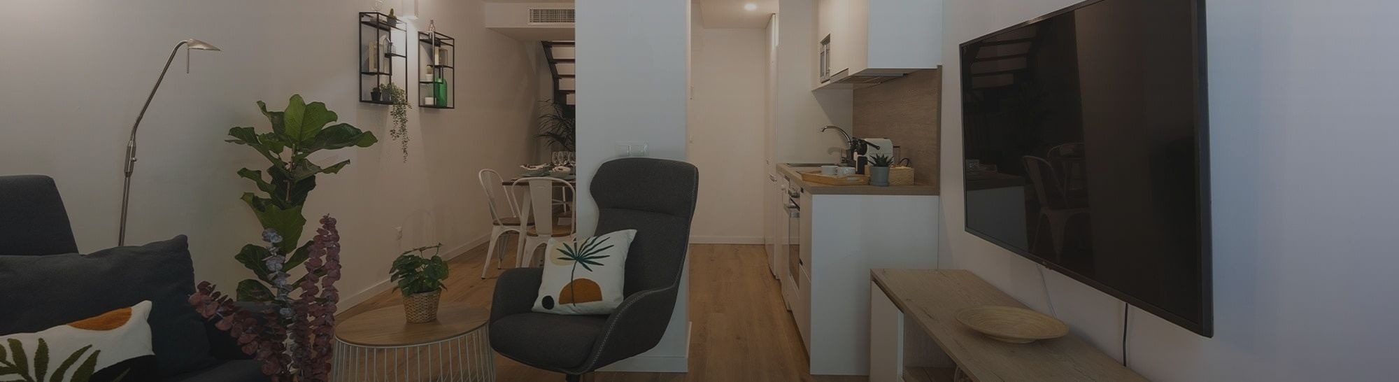 Un interior moderno y diáfano de un apartamento, con sala de estar, comedor y cocina integrados.