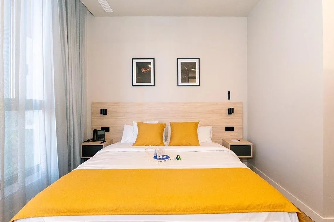 una habitación de hotel con una cama y dos cuadros en la pared