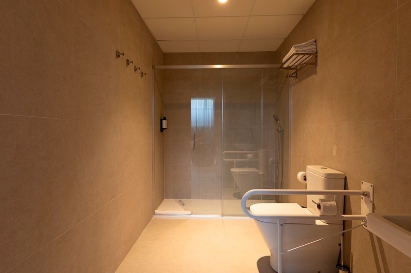 una cama con sábanas blancas y almohadas blancas