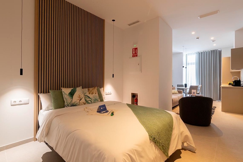 una cama con sábanas blancas y almohadas blancas