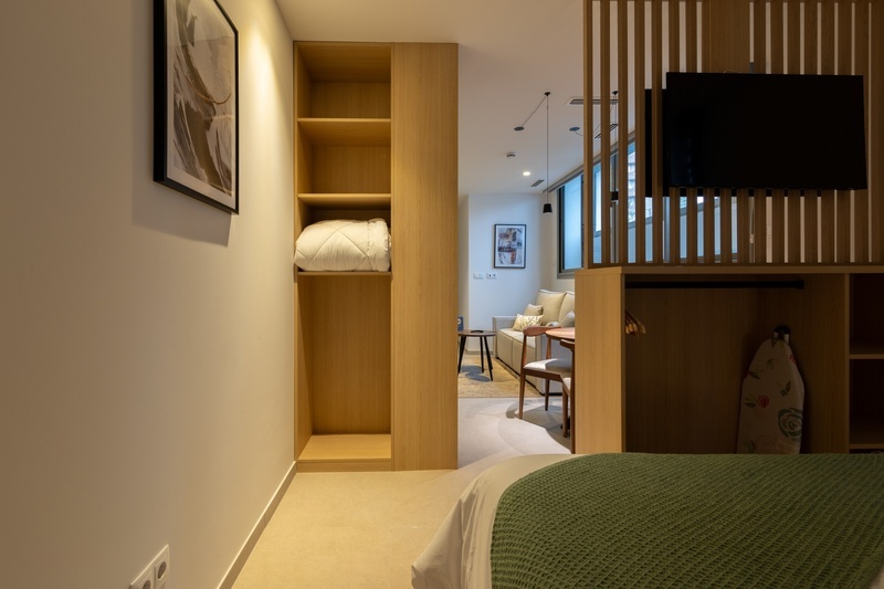 una cama con dos almohadas blancas y una cabecera de madera