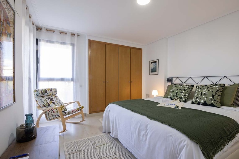 una cama con dos almohadas blancas y una cabecera de madera