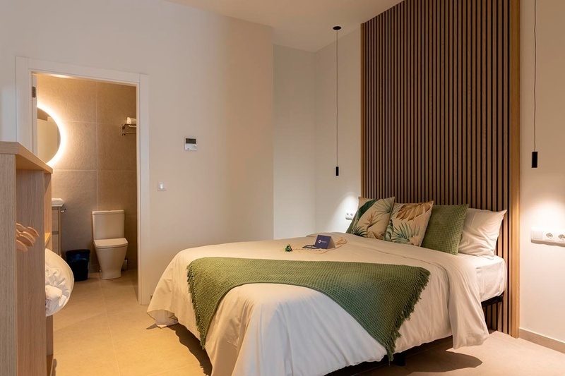 una cama con sábanas blancas y almohadas blancas