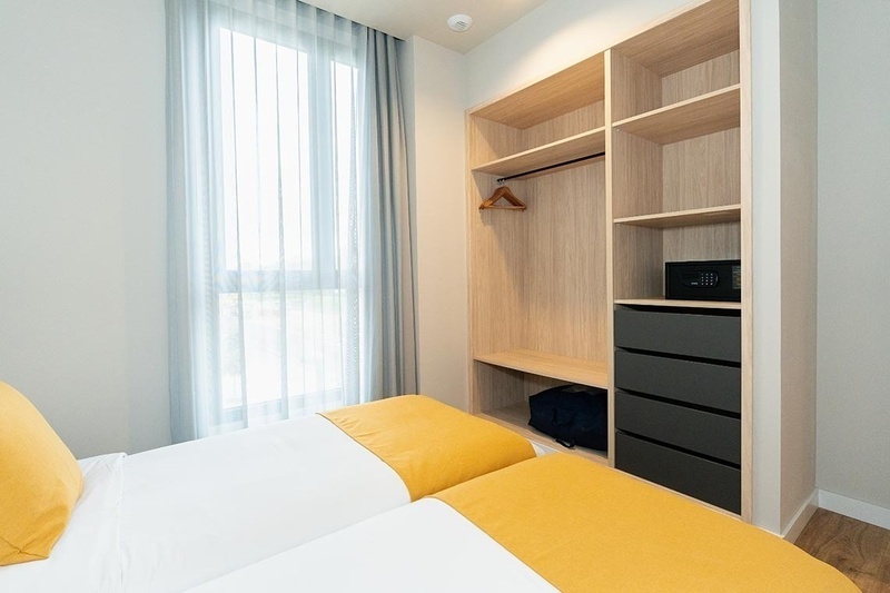 una cama con sábanas blancas y almohadas blancas