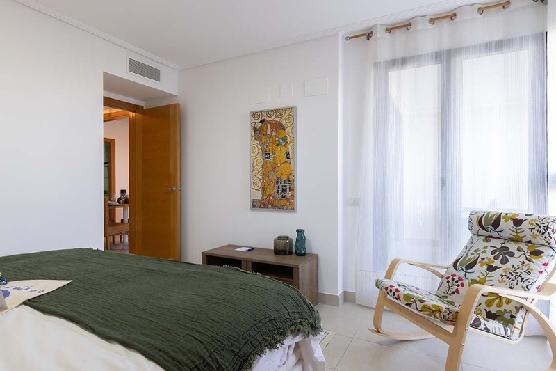 una cama con dos almohadas blancas y una cabecera de madera