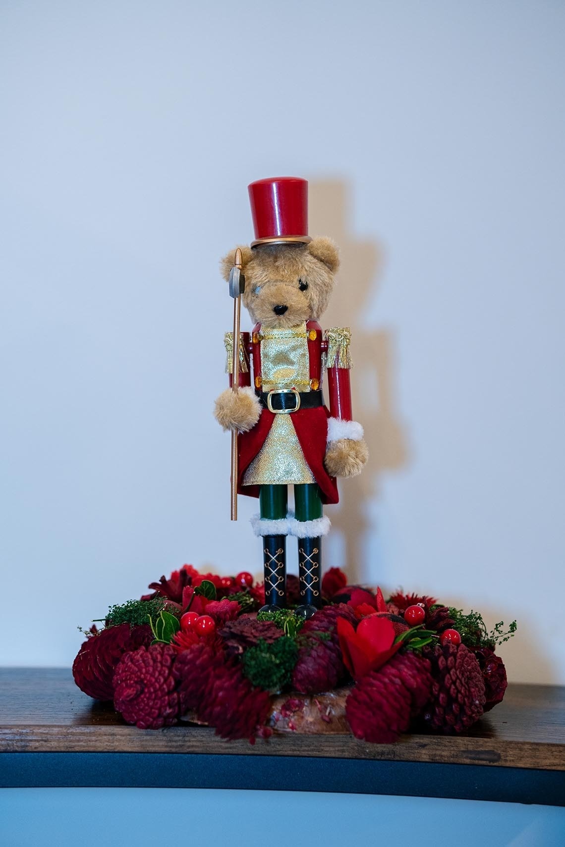 un oso de peluche vestido como cascanueces sostiene un tambor