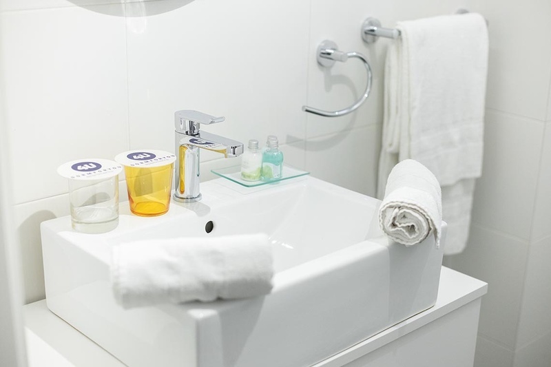 una cama con dos almohadas blancas y una cabecera de madera