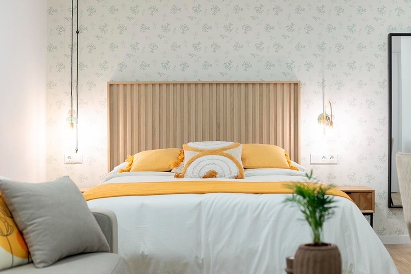 una cama con sábanas blancas y almohadas blancas