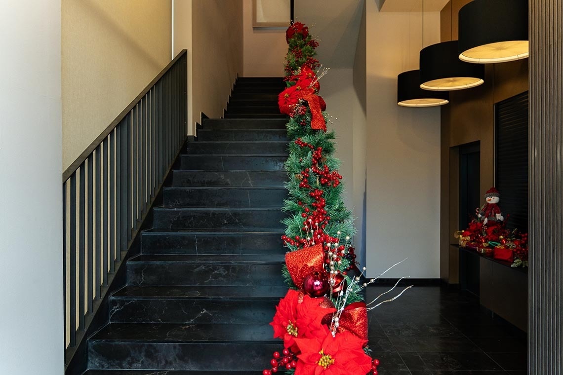 las escaleras están decoradas para la navidad con adornos rojos y verdes