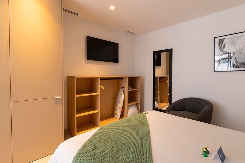 una cama con sábanas blancas y almohadas blancas