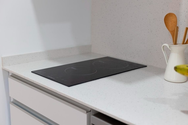 una cama con sábanas blancas y almohadas blancas