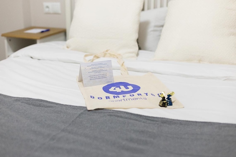 una cama con dos almohadas blancas y una cabecera de madera