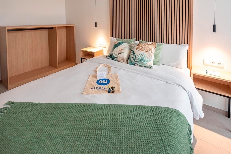 una cama con sábanas blancas y almohadas blancas