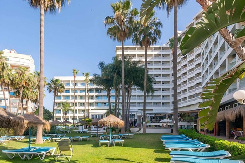 a large white building with palm trees in front of it